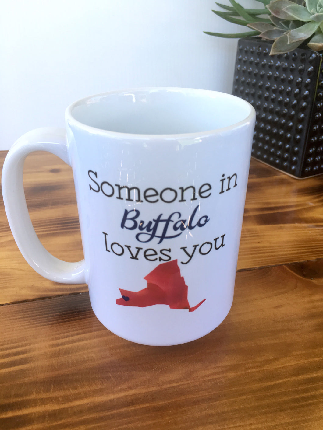 white coffee mug with the words someone in buffalo loves you. 